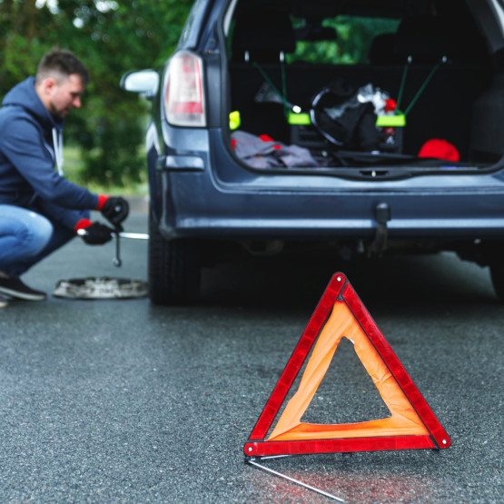 Mężczyzna wymieniający samodzielnie koło, ilustracja do artykułu