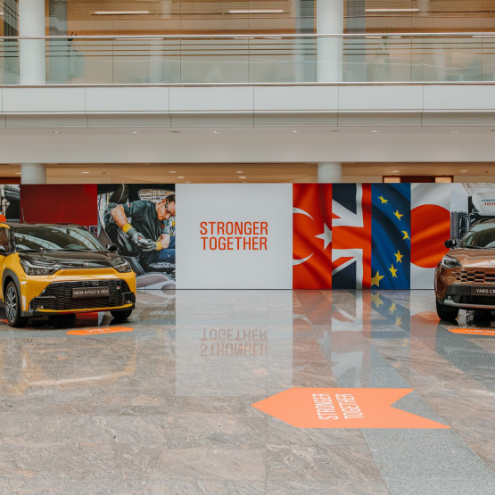 Dwa modele Toyoty na tle flag partnerów europejskiego przemysłu; zdjęcie: newsroom.toyota.eu