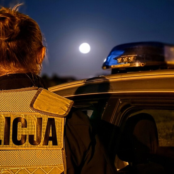 Policjantka przy radiowozie podczas nocnych działań, zdjęcie ilustracyjne do komunikatu, fot. opolska.policja.gov.pl